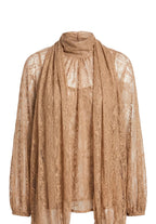 A sheer, patterned lace turtleneck top and matching draped scarf in a warm tan or camel color, displayed on a neutral light gray background.